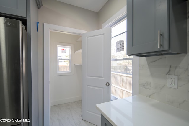 interior space featuring baseboards and marble finish floor