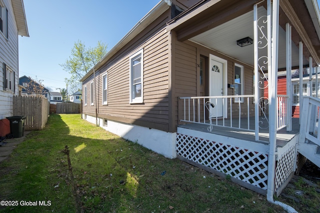 view of side of property featuring a lawn and fence