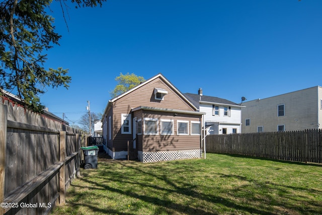 rear view of house featuring a yard, a fenced backyard, and entry steps
