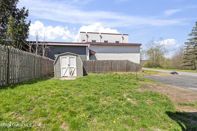 view of yard featuring fence, an outbuilding, and a shed