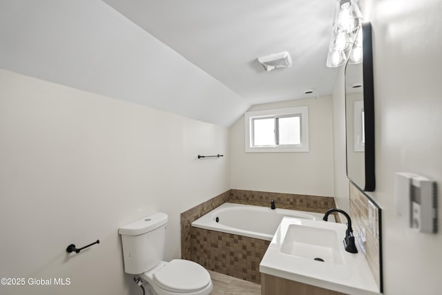 bathroom with toilet, vaulted ceiling, a garden tub, and vanity