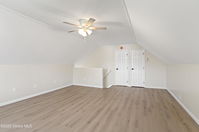 additional living space with baseboards, a ceiling fan, light wood-style flooring, and lofted ceiling