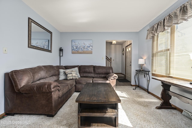 living room featuring stairway and baseboards