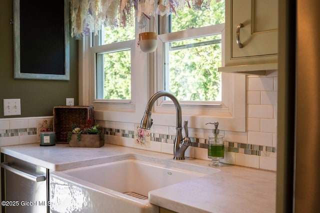 details featuring a sink, light countertops, tasteful backsplash, and stainless steel dishwasher