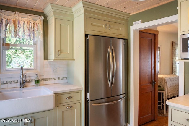 kitchen featuring light countertops, a sink, tasteful backsplash, and stainless steel appliances
