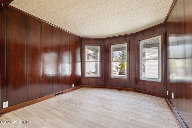 5 Barney St, Schenectady, NY 12307 - empty room featuring wooden walls, visible vents, baseboard heating, and light wood finished floors
