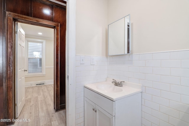 5 Barney St, Schenectady, NY 12307 - bathroom with visible vents, tile walls, wood finished floors, a wainscoted wall, and vanity