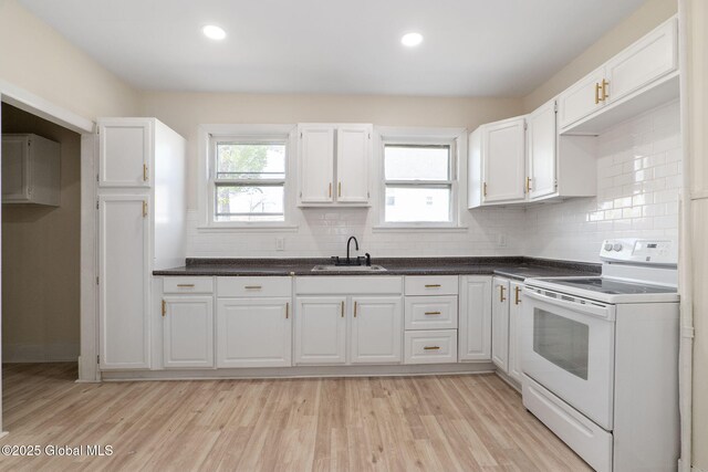 5 Barney St, Schenectady, NY 12307 - kitchen featuring white cabinets, white range with electric stovetop, dark countertops, a sink, and light wood-style floors