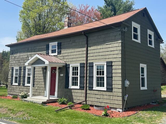 colonial-style house with a front yard and a chimney