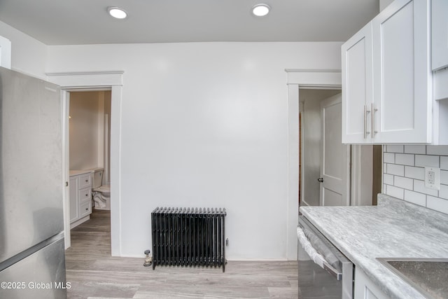 1538 Nott St, Schenectady, NY 12308 - kitchen with radiator heating unit, stainless steel appliances, white cabinets, light countertops, and tasteful backsplash
