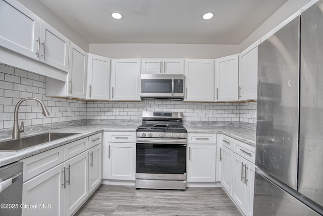 1538 Nott St, Schenectady, NY 12308 - kitchen with stainless steel appliances, a sink, white cabinets, light countertops, and recessed lighting