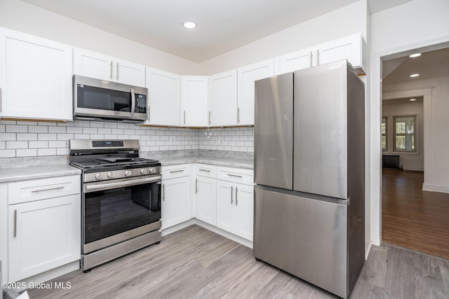 1538 Nott St, Schenectady, NY 12308 - kitchen with stainless steel appliances, light countertops, light wood-type flooring, white cabinetry, and recessed lighting