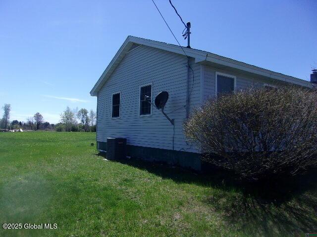view of home's exterior featuring a yard and central AC