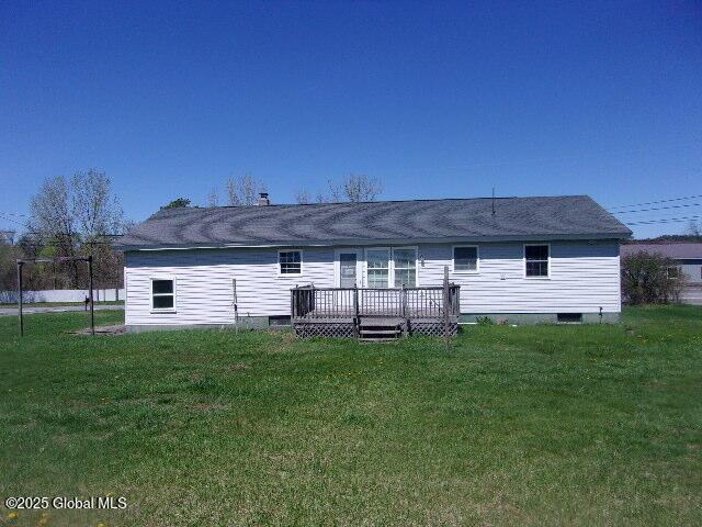 rear view of house with a wooden deck, a yard, and crawl space