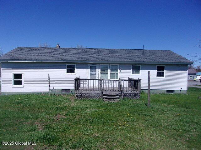 rear view of property featuring a wooden deck and a yard
