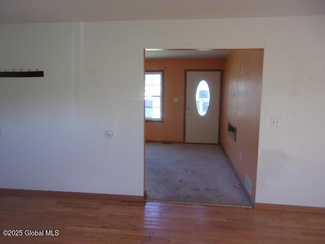 foyer featuring baseboards and wood finished floors