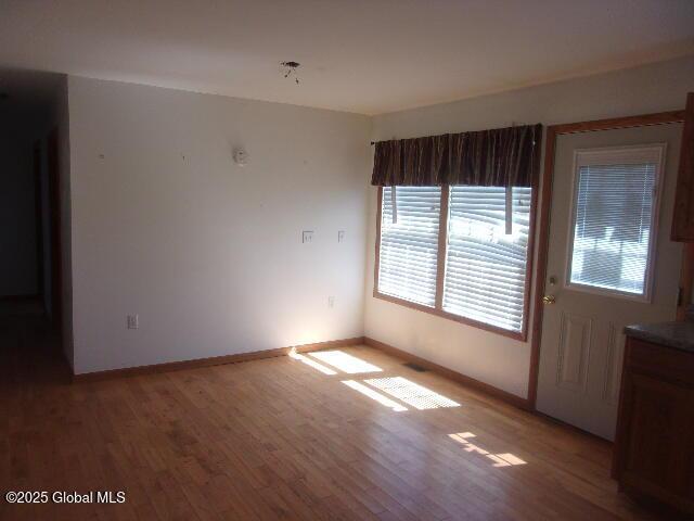 empty room with baseboards and light wood finished floors