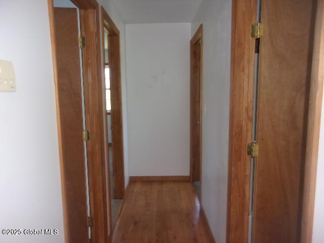 hallway with baseboards and wood finished floors