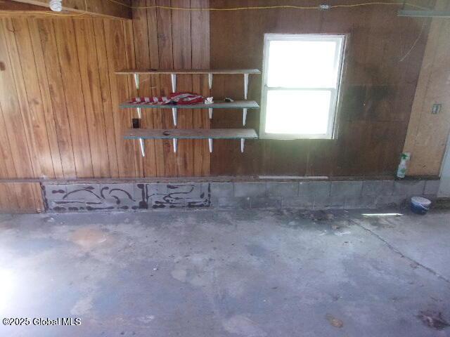 interior space featuring wood walls and concrete floors