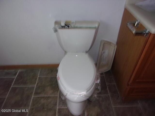 bathroom featuring tile patterned floors, baseboards, and toilet