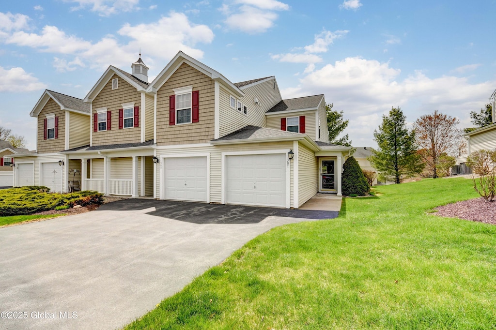 view of front facade with an attached garage, aphalt driveway, and a front yard