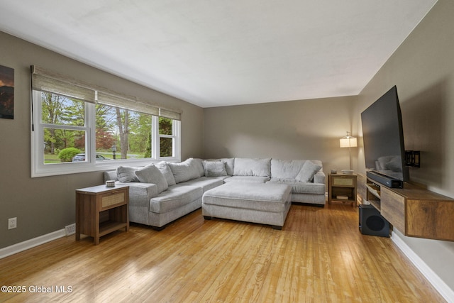 living area featuring light wood finished floors and baseboards