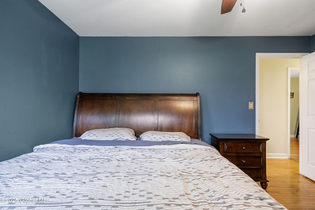 bedroom featuring wood finished floors, a ceiling fan, and baseboards