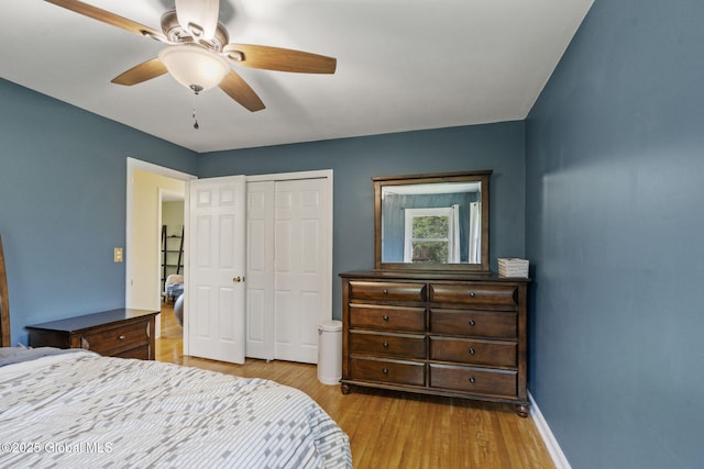 bedroom with wood finished floors, a closet, baseboards, and a ceiling fan