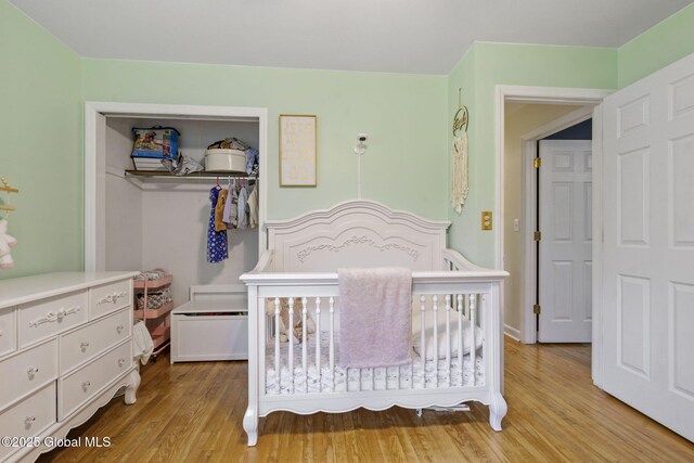 bedroom with wood finished floors and a closet