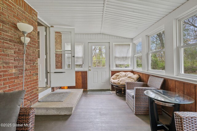 sunroom featuring healthy amount of natural light, wood finished floors, and lofted ceiling