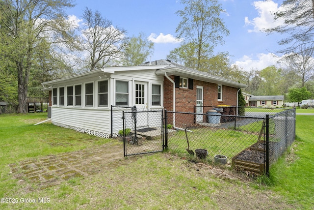 rear view of house with a gate and brick siding