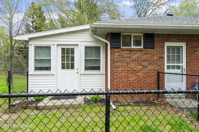view of property exterior featuring brick siding and a shingled roof