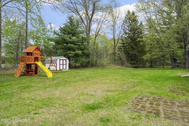 view of green lawn with a storage shed, a playground, and an outbuilding