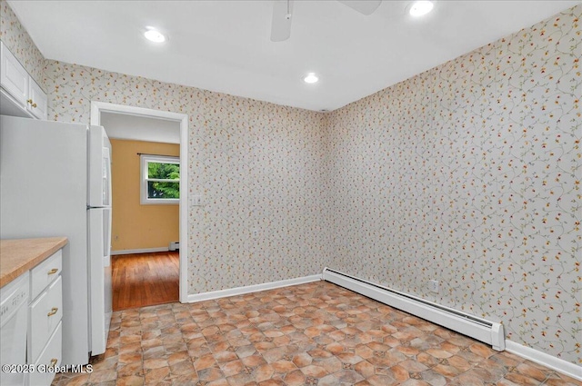 empty room featuring a baseboard heating unit, wallpapered walls, baseboards, and recessed lighting