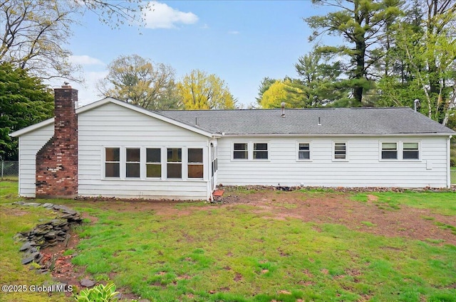 back of house with a lawn and a shingled roof