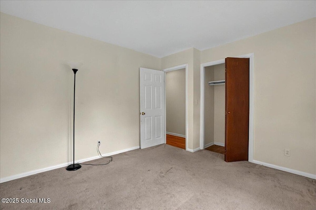 unfurnished bedroom featuring carpet flooring, baseboards, and a closet