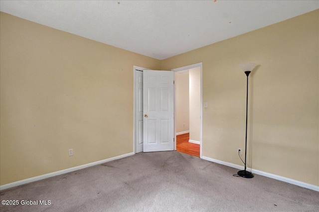 carpeted empty room with baseboards