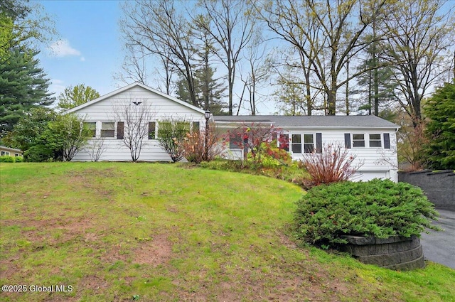 single story home with an attached garage and a front lawn