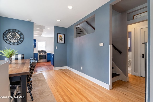 dining room with stairs, recessed lighting, baseboards, and light wood-style floors