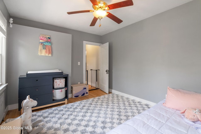 bedroom featuring baseboards, a ceiling fan, and wood finished floors
