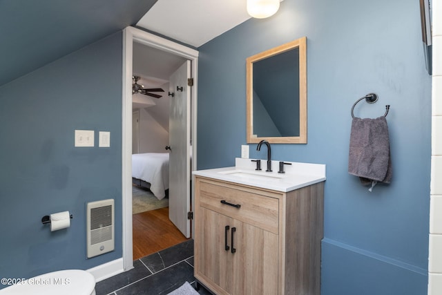 ensuite bathroom featuring vanity, tile patterned flooring, toilet, ensuite bathroom, and vaulted ceiling