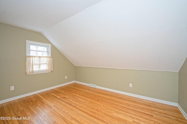 bonus room featuring baseboards, lofted ceiling, and light wood-type flooring