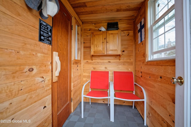 sitting room featuring wood ceiling, tile patterned floors, and wooden walls