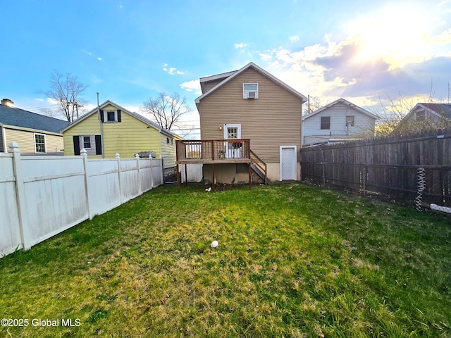 back of property featuring a fenced backyard, a wooden deck, and a lawn