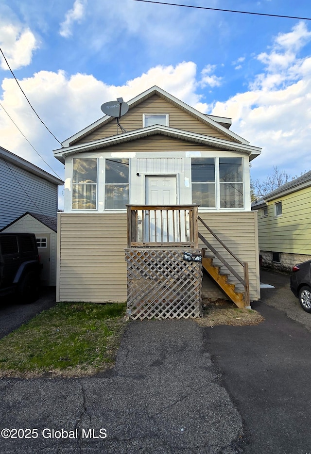 view of front of home with a sunroom and stairs