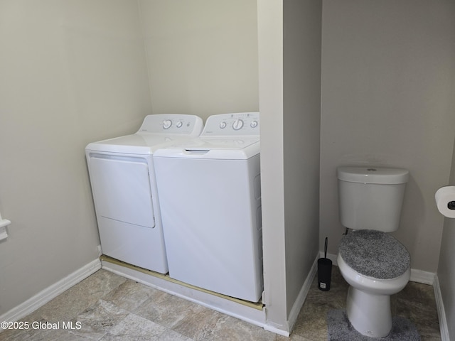 washroom with laundry area, baseboards, and washer and dryer