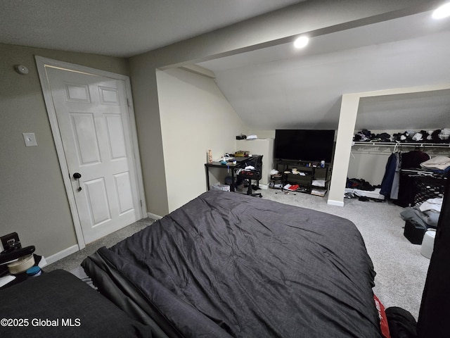 bedroom with baseboards, lofted ceiling, carpet, and a closet