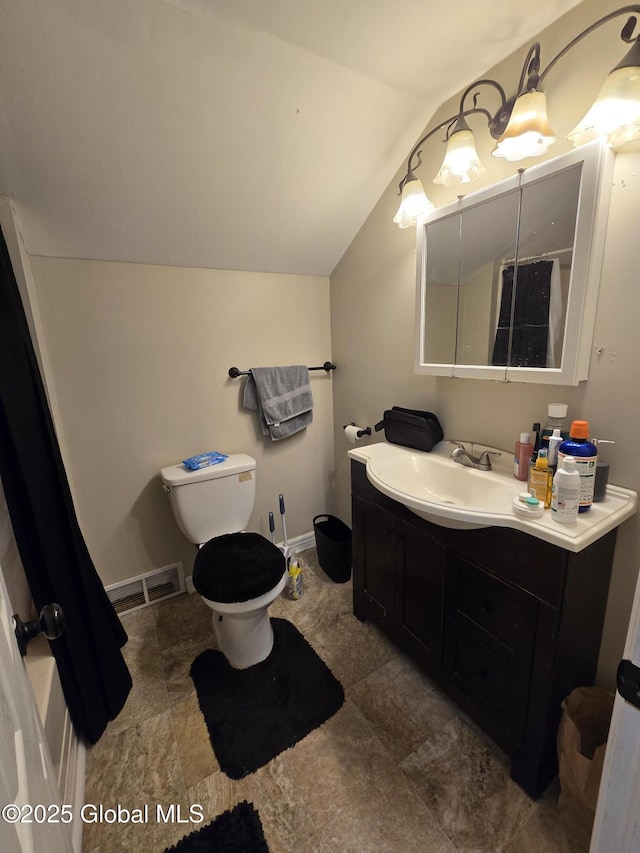 bathroom featuring vanity, toilet, baseboards, lofted ceiling, and visible vents