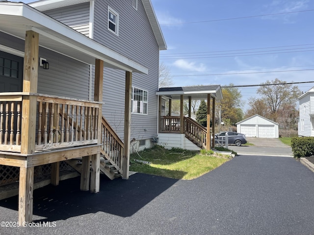 view of home's exterior featuring covered porch, an outdoor structure, and stairway