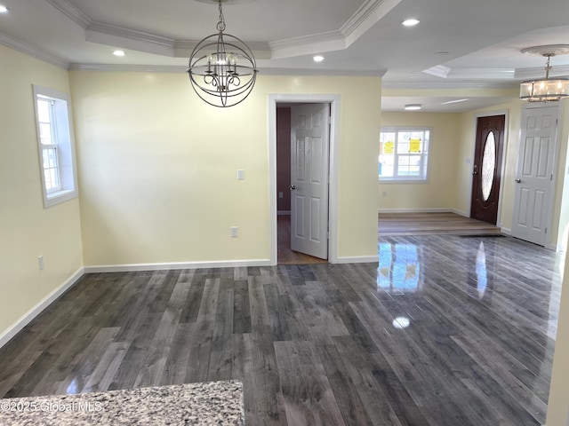 unfurnished dining area featuring dark wood-style flooring, crown molding, a chandelier, a tray ceiling, and recessed lighting